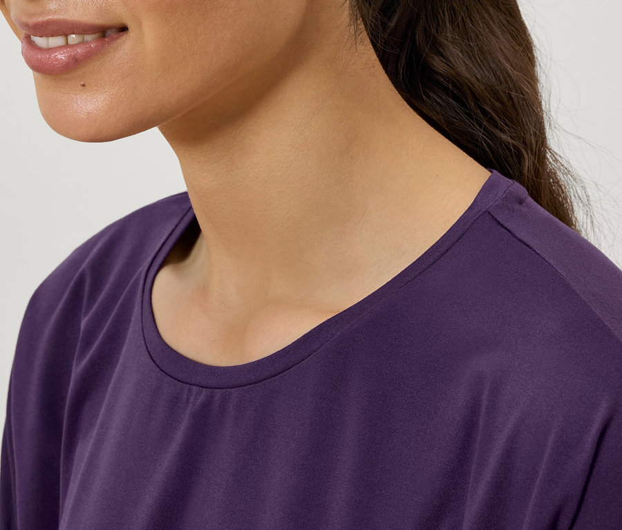 Zbliżenie kobiety w fioletowej koszulce z okrągłym dekoltem.