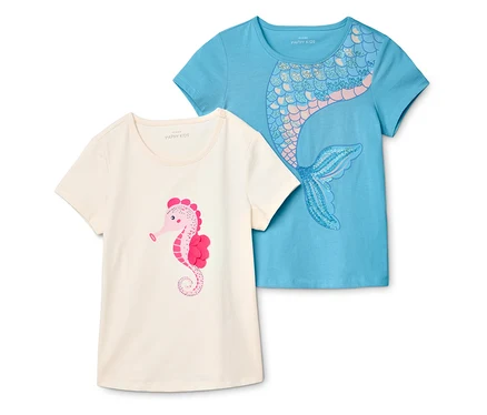 Dwa T-shirty leżą jeden na drugim. Jeden jest jasno-beżowy z różowym konikiem morskim, drugi jest jasno-niebieski z motywem syreny.