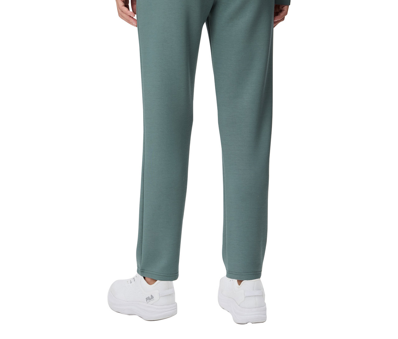 Widok z tyłu osoby ubranej w damskie spodnie FILA Plazzohose z mieszanki modalowej i białe tenisówki.