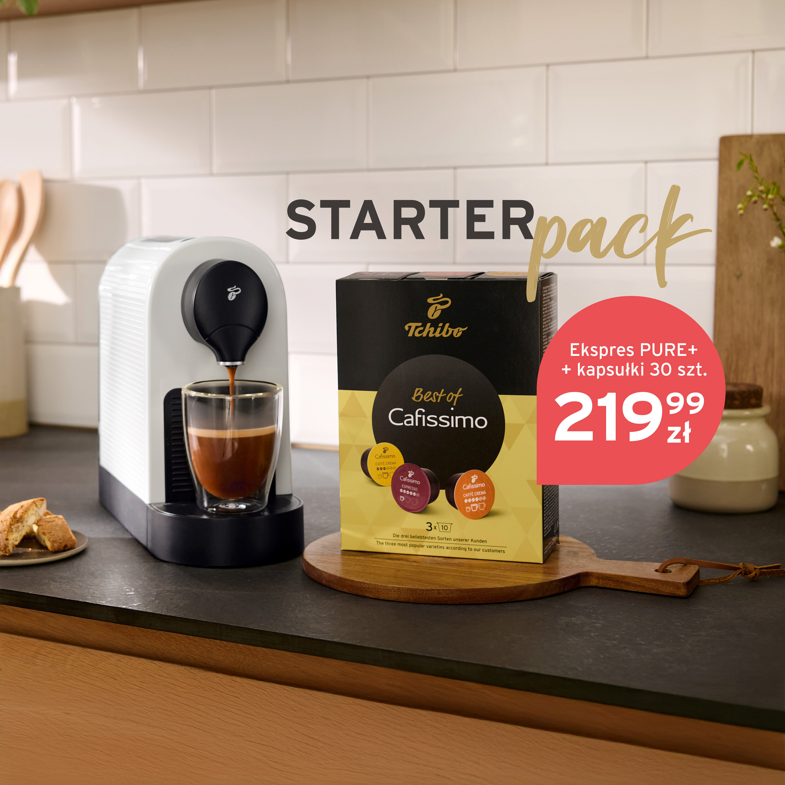 Kawa leje się z białego ekspresu Tchibo do szklanki. Obok stoi opakowanie kapsułek Tchibo Best of Cafissimo.