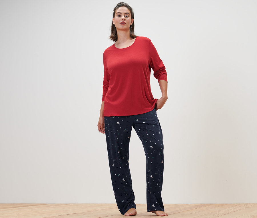 Kobieta pozuje w niebieskiej piżamie.