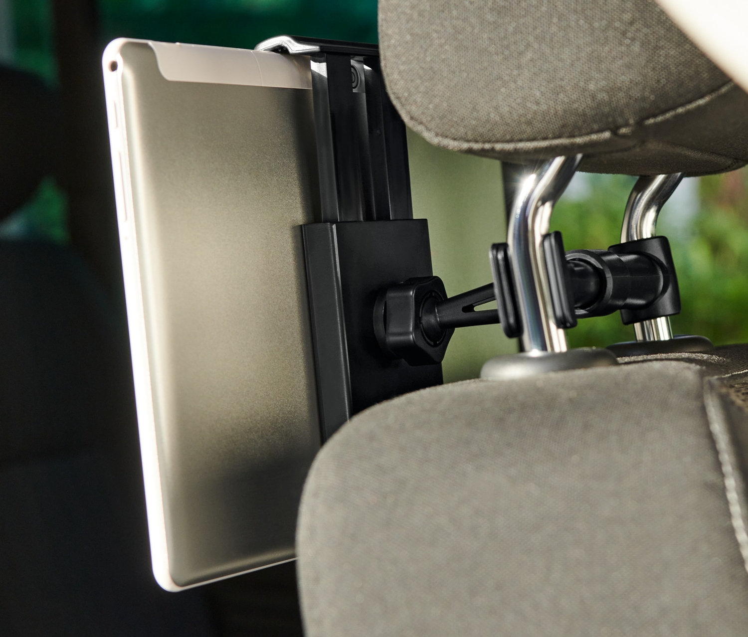 Tablet przymocowany do uchwytu na tablet samochodowy, który jest przymocowany do zagłówka siedzenia.