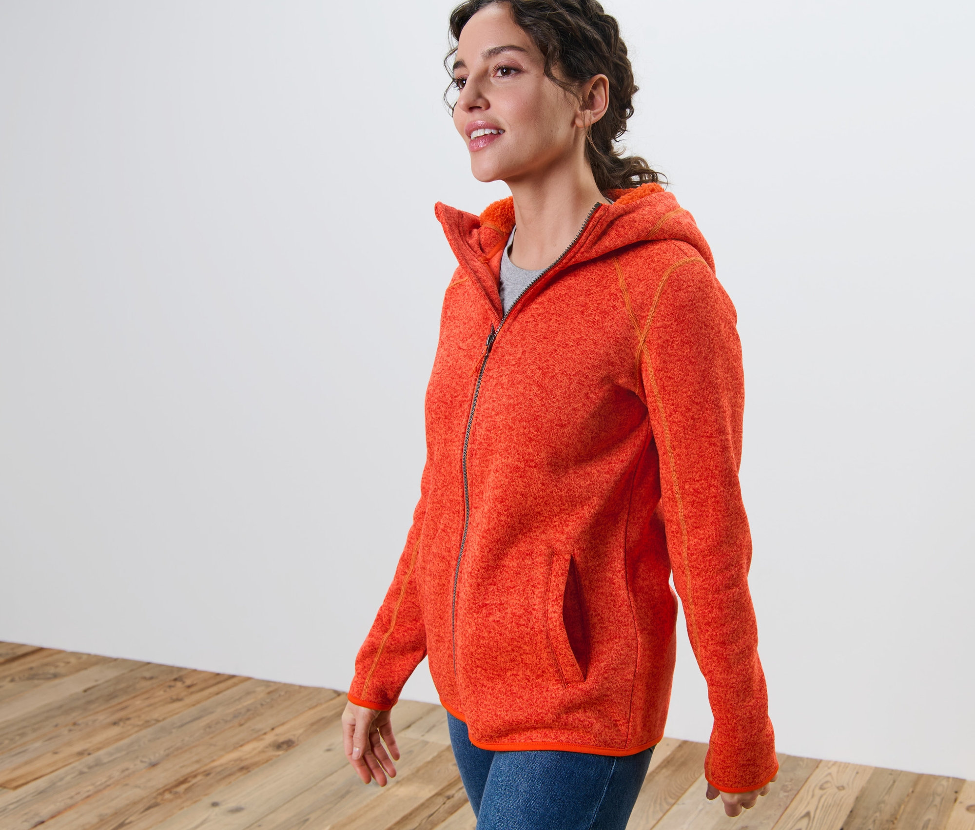 Kobieta ma na sobie bluzę z kapturem z dzianiny polarowej, pomarańczowy melanż.