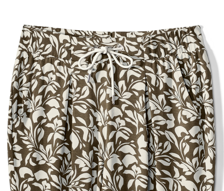 Szczegół spodni z dżerseju z nadrukiem w liście i sznurkiem w pasie.