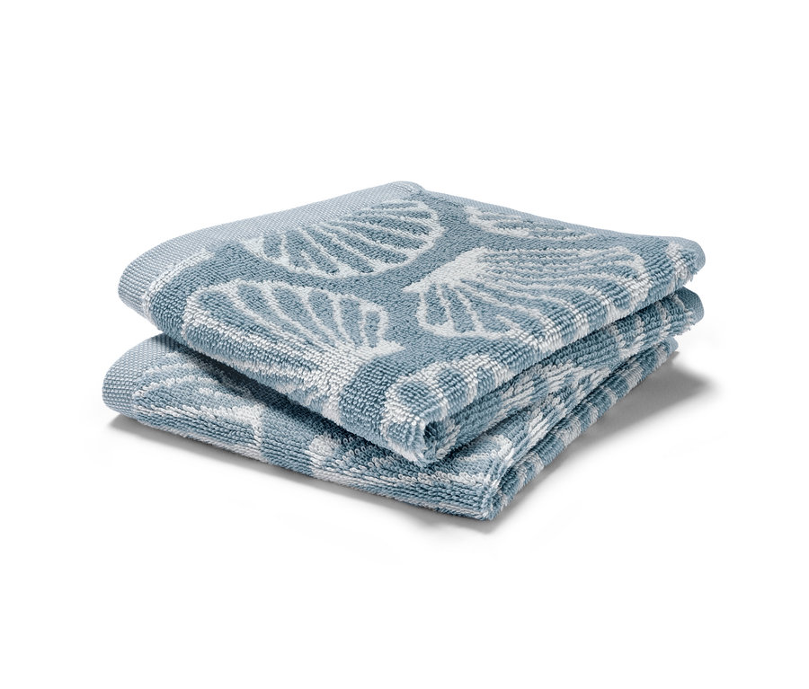 Dwa złożone niebieskie Małe ręczniki, 2 sztuki z nadrukiem muszelek.