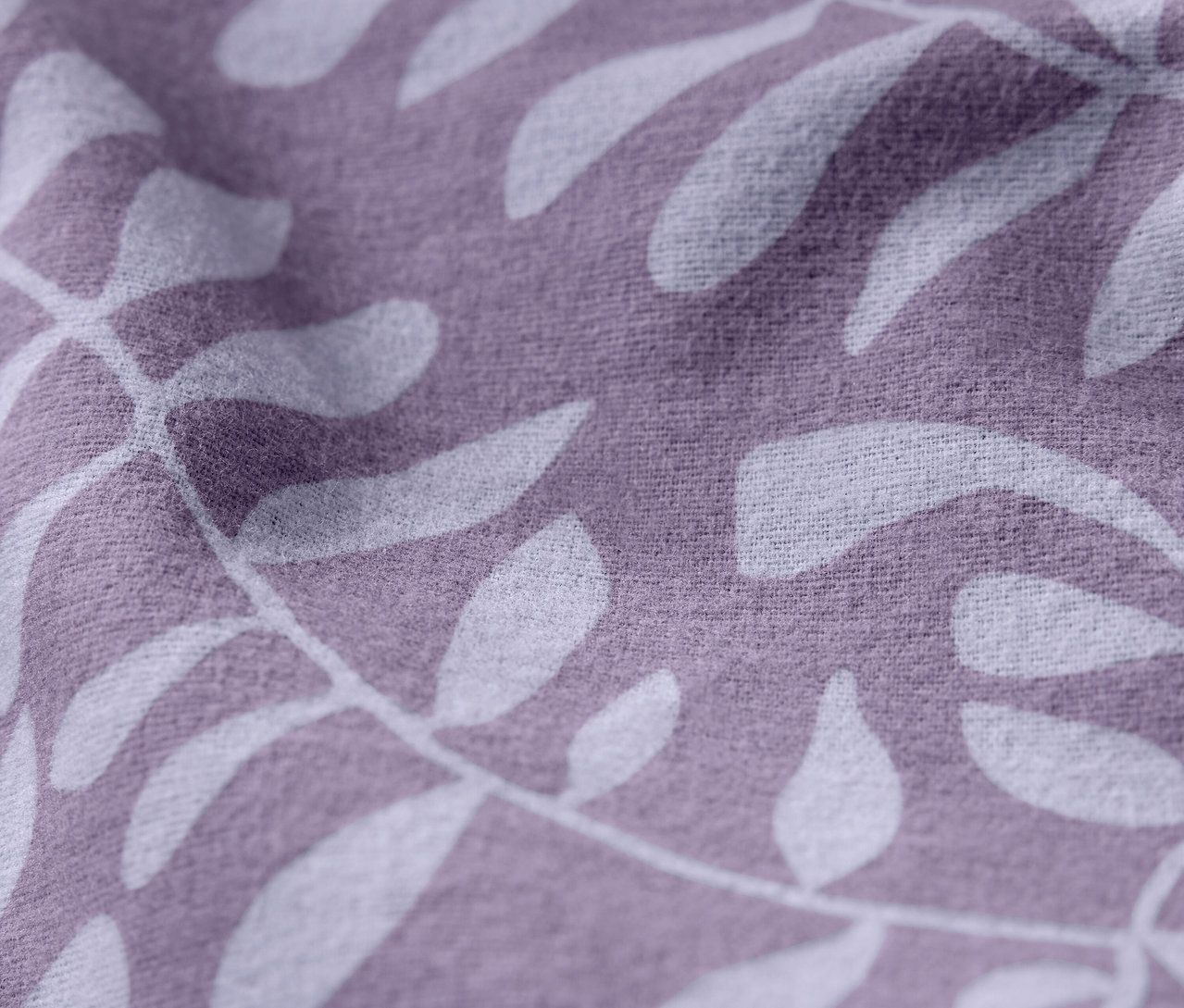 Zbliżenie fioletowej tkaniny z białym wzorem liści.