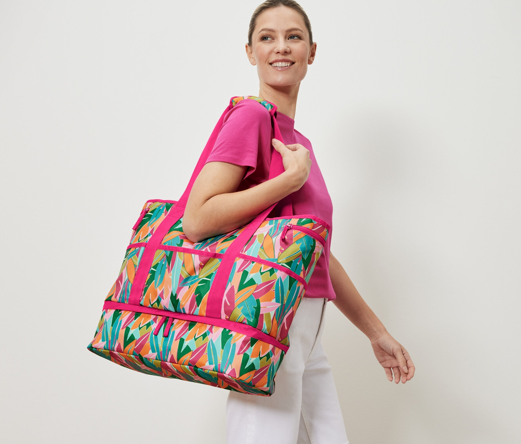 Kobieta niesie torbę plażową z nadrukiem.