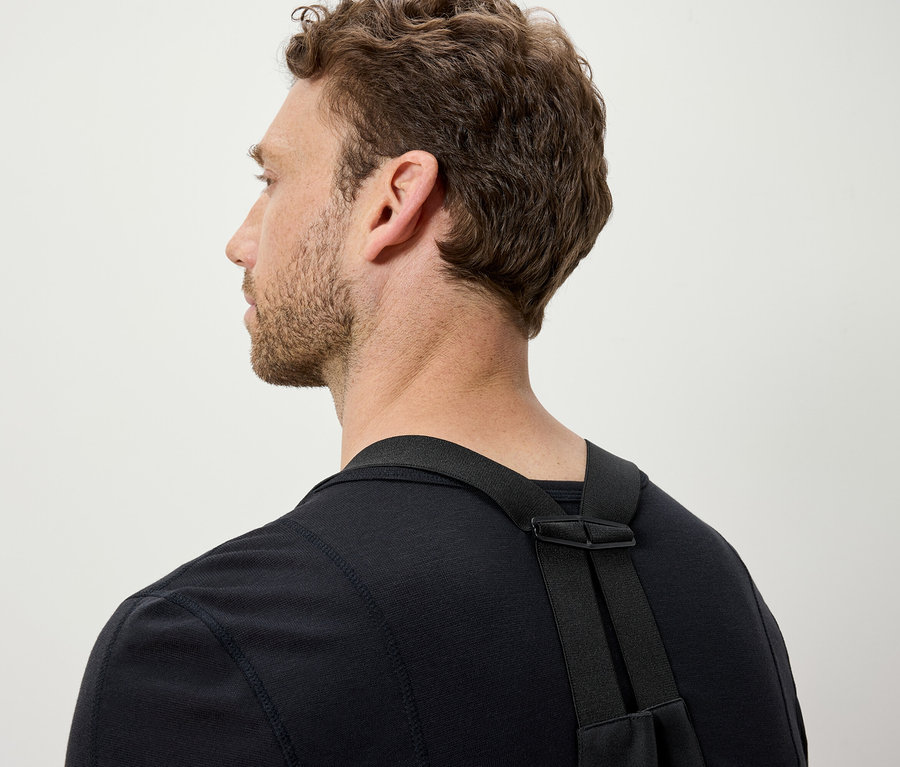 Mężczyzna z brązowymi włosami ma na sobie czarną koszulkę i czarne paski.