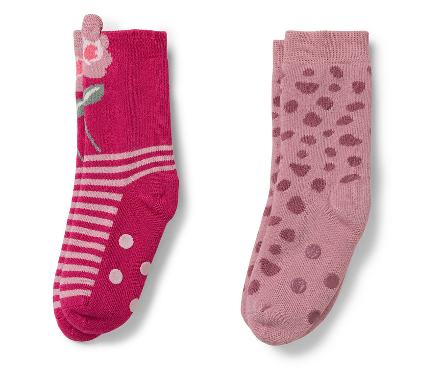 Dwie pary skarpetek. Jedna para różowa we wzór kwiatowy, druga jasnoróżowa w kropki.