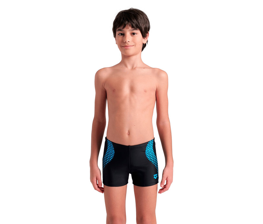 Chłopiec z ciemnymi włosami nosi czarne kąpielówki z niebieskim wzorem.