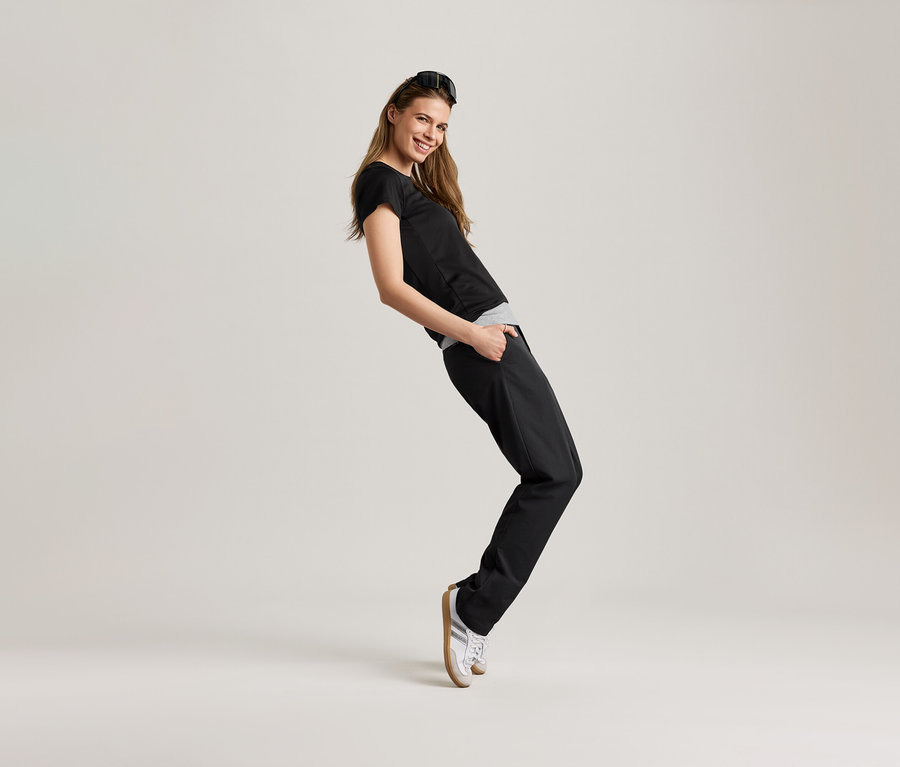 Kobieta pozuje w czarnej koszulce sportowej.