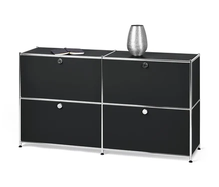 Czarna szafka typu sideboard „CN3” z 4 klapami. Na górze leży notatnik i srebrny wazon.