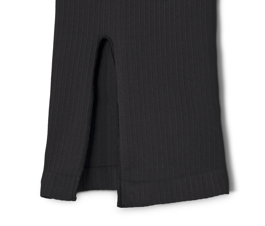 Zbliżenie na czarne spodnie sportowe z rozszerzanymi nogawkami z rozcięciem.