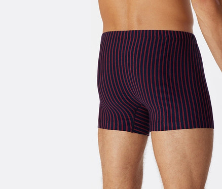 Mężczyzna od tyłu ma na sobie czerwone bokserki z bawełny ekologicznej SCHIESSER.