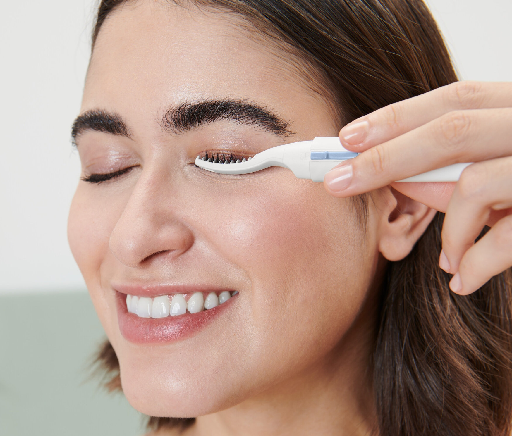 Kobieta używa podgrzewanej zalotki do rzęs.