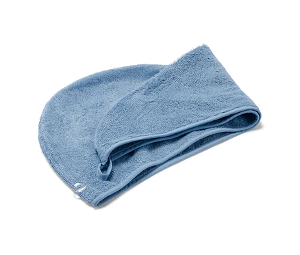 Niebieski ręcznik-turban na białym tle.