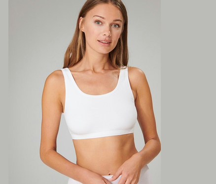 Kobieta ma na sobie białą braletkę z bawełny ekologicznej SCHIESSER, 2 sztuki.