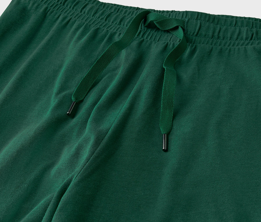 Szczegół zielonych spodni dresowych ze sznurkiem.