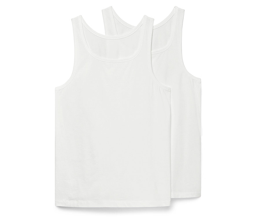 Dwie białe koszulki na ramiączkach leżą na sobie.