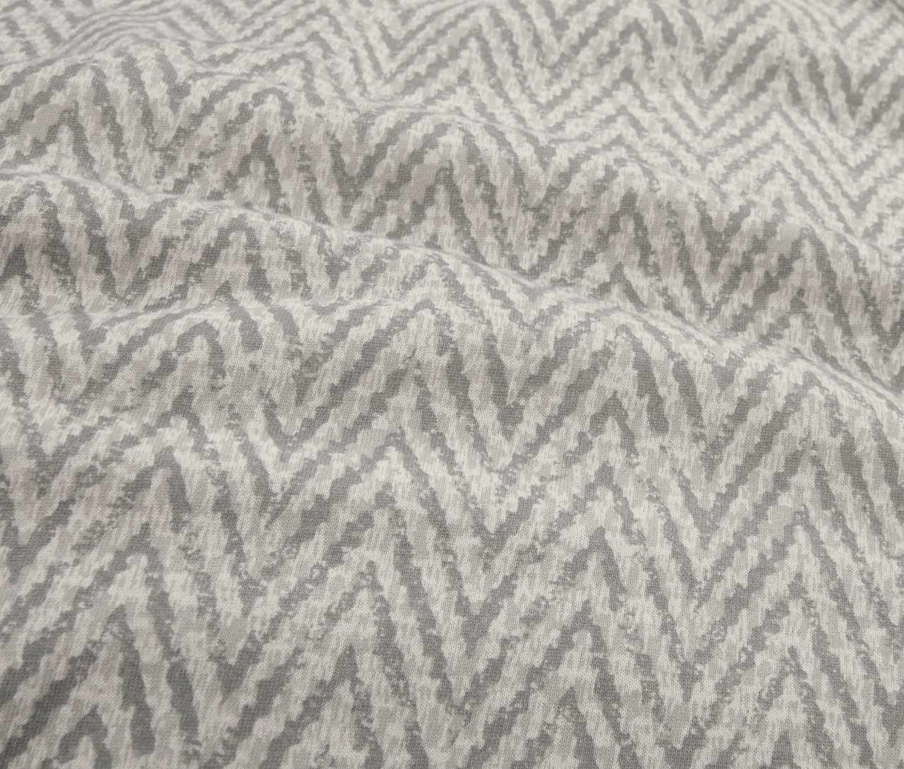 Zbliżenie na pościel z zimowego dżerseju w standardowym rozmiarze z szarym zygzakowatym wzorem.