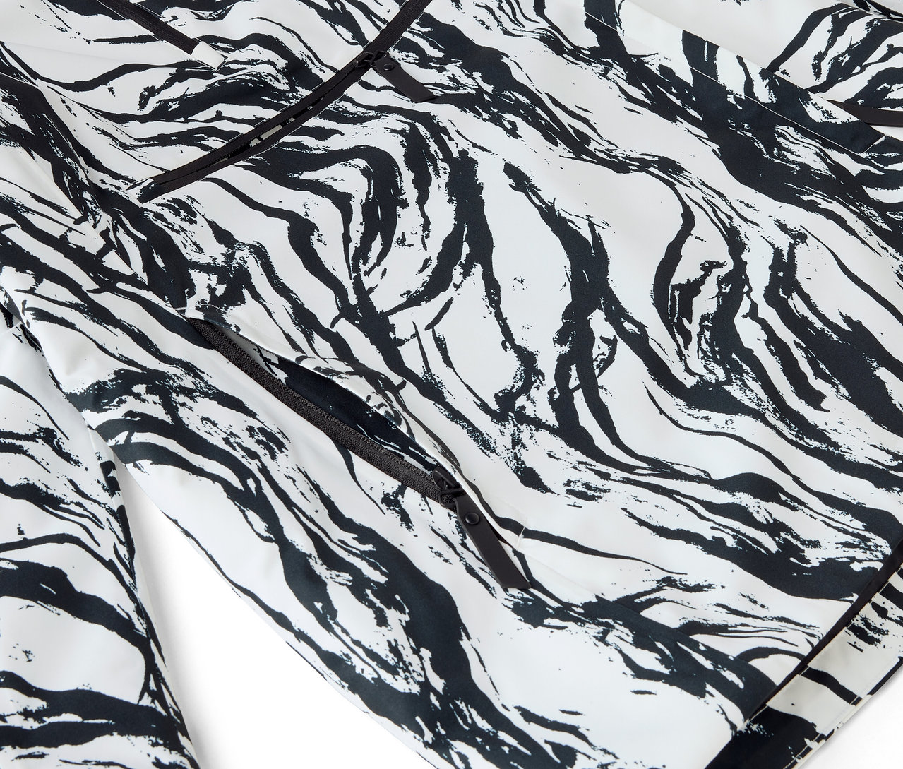 Zbliżenie białej piżamy z czarnym abstrakcyjnym wzorem i lamówką.