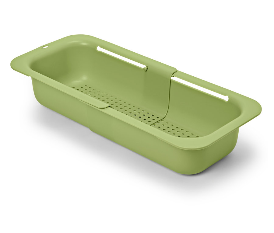 Zielony, rozsuwany durszlak do zlewu na białym tle.