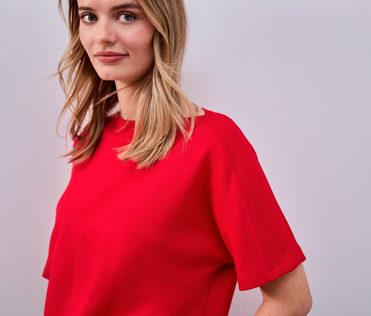 Kobieta ma na sobie czerwoną koszulkę Street One.
