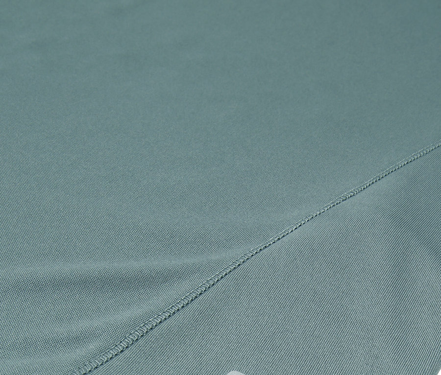 Zbliżenie turkusowych szortów Fila z srebrnym logo.