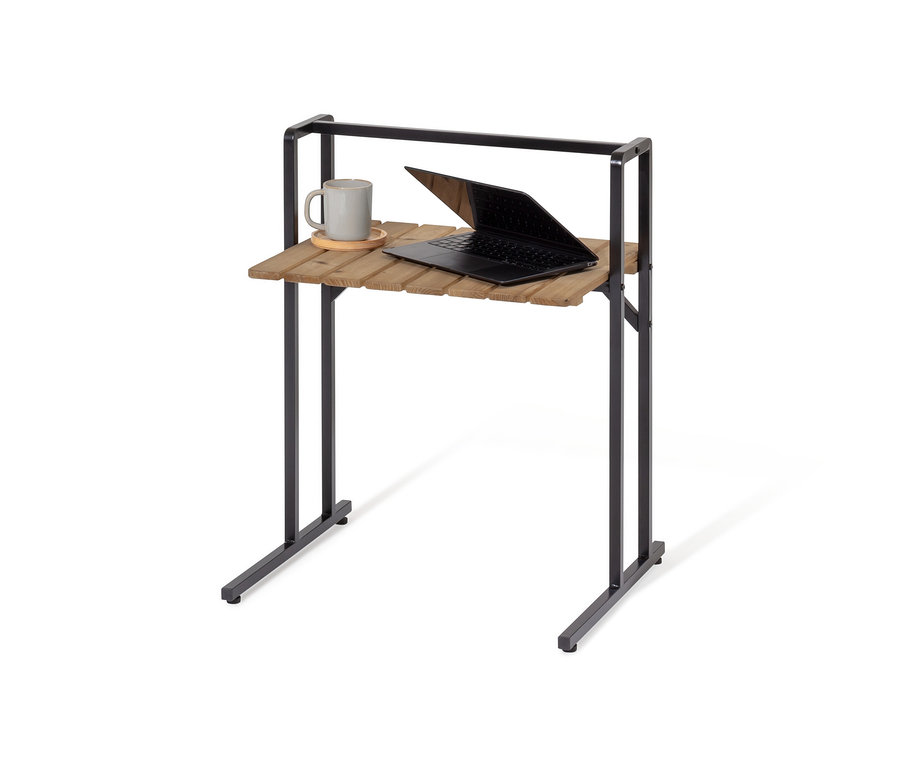 Na stoliku w kształcie litery C z dużym blatem leży szary kubek i otwarty laptop.