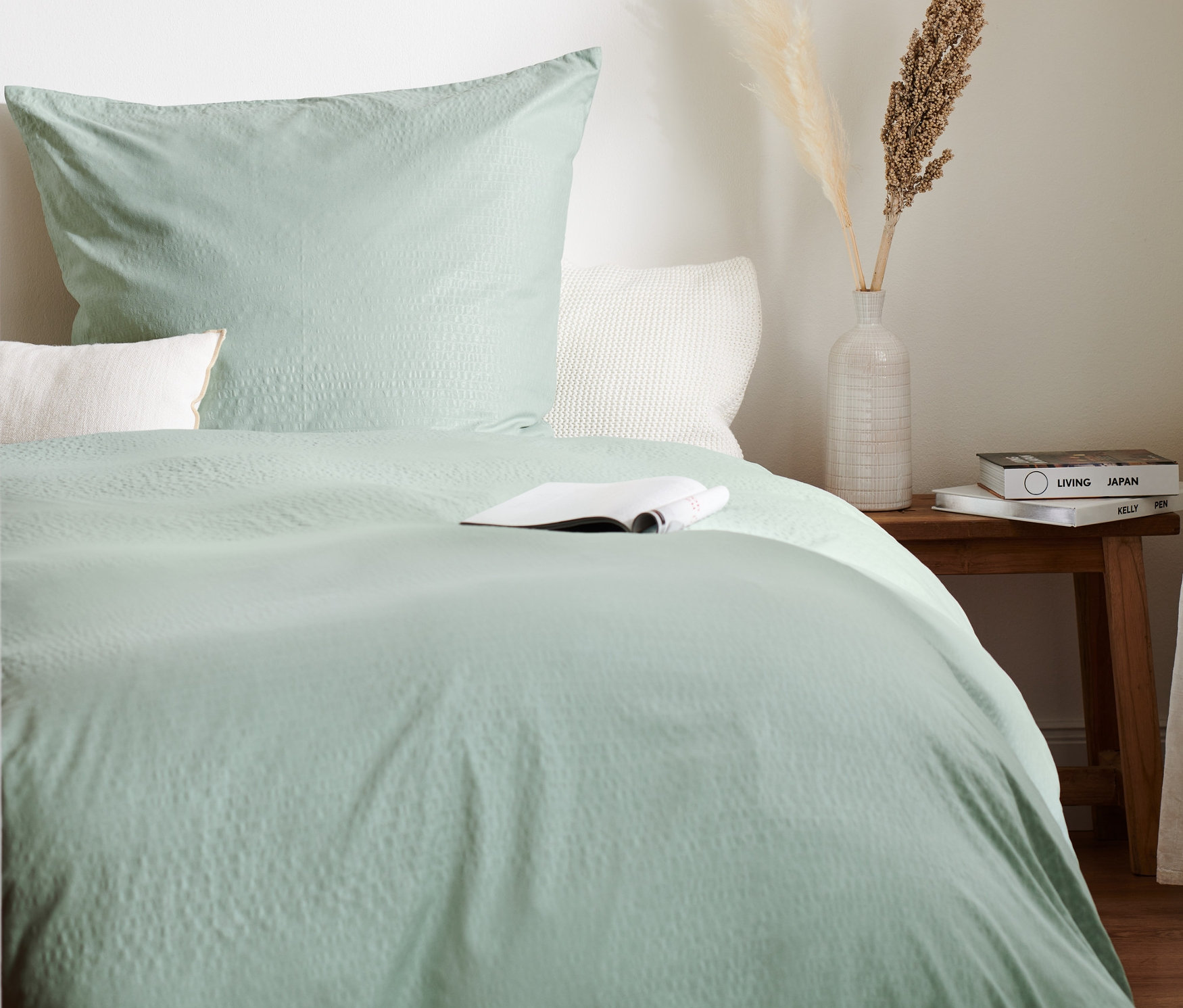 Zielona pościel z kory w rozmiarze standardowym, niestandardowym i podwójnym na łóżku z książką.