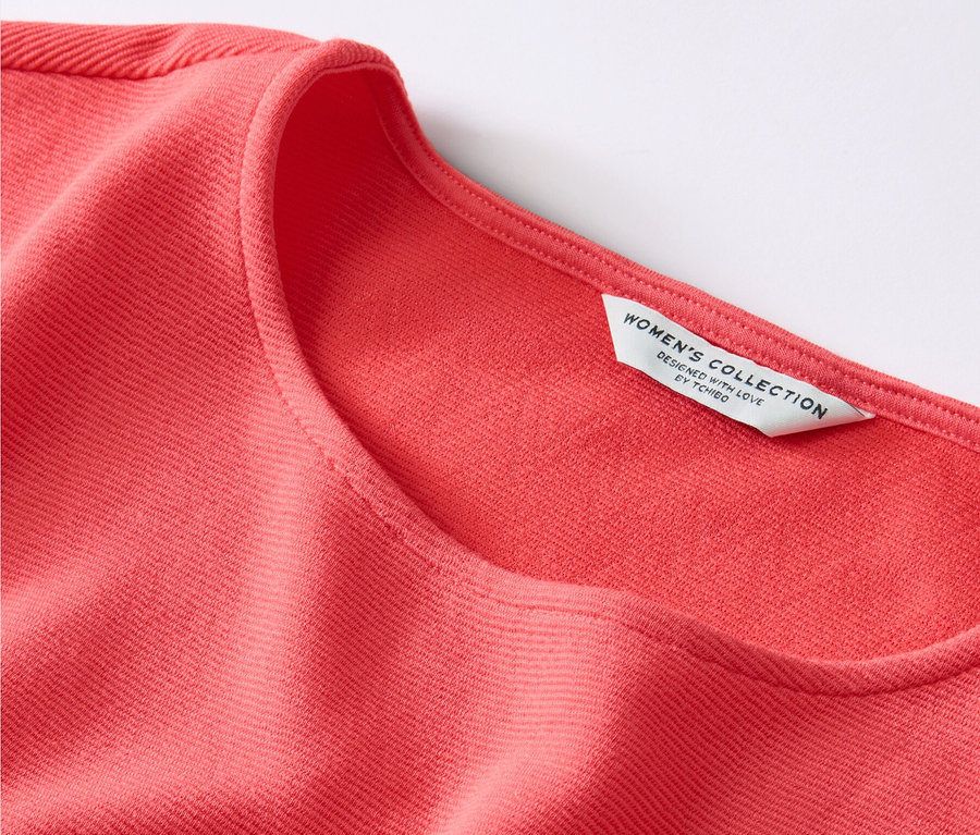 Zbliżenie na koralową bluzkę.