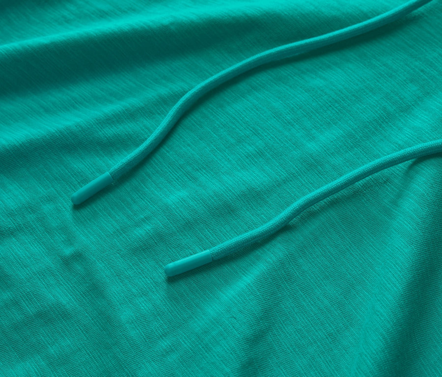 Zbliżenie turkusowej bluzy z kapturem z dżerseju ze sznurkiem.