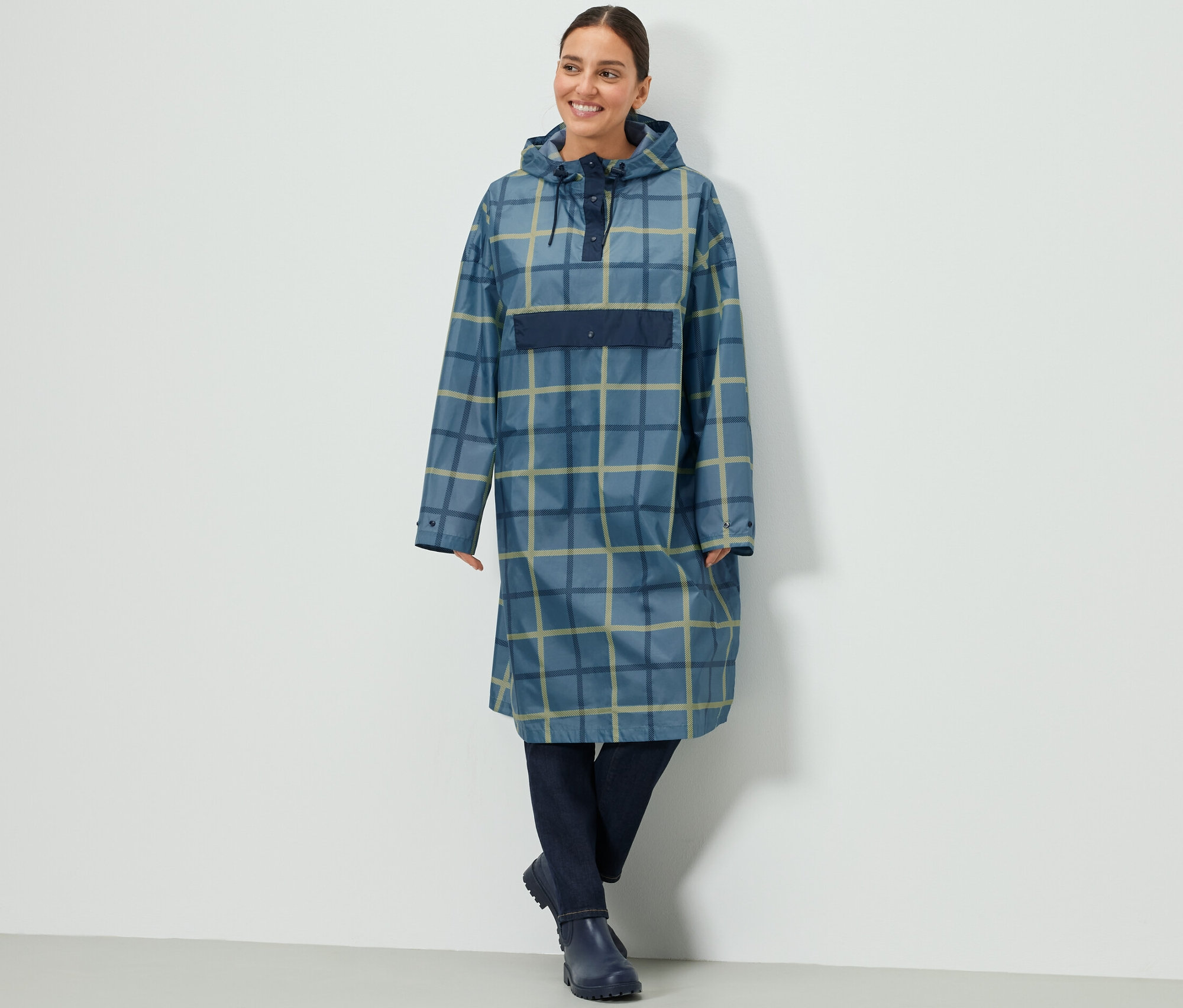 Kobieta w ponczo przeciwdeszczowym w kratę z rękawami.