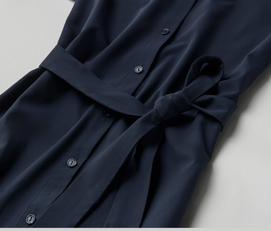 Zbliżenie na sukienkę funkcyjną z guzikami i paskiem.