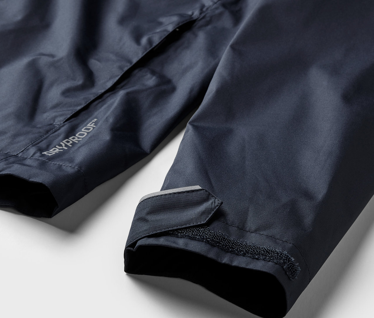 Szczegół granatowej kurtki przeciwdeszczowej.