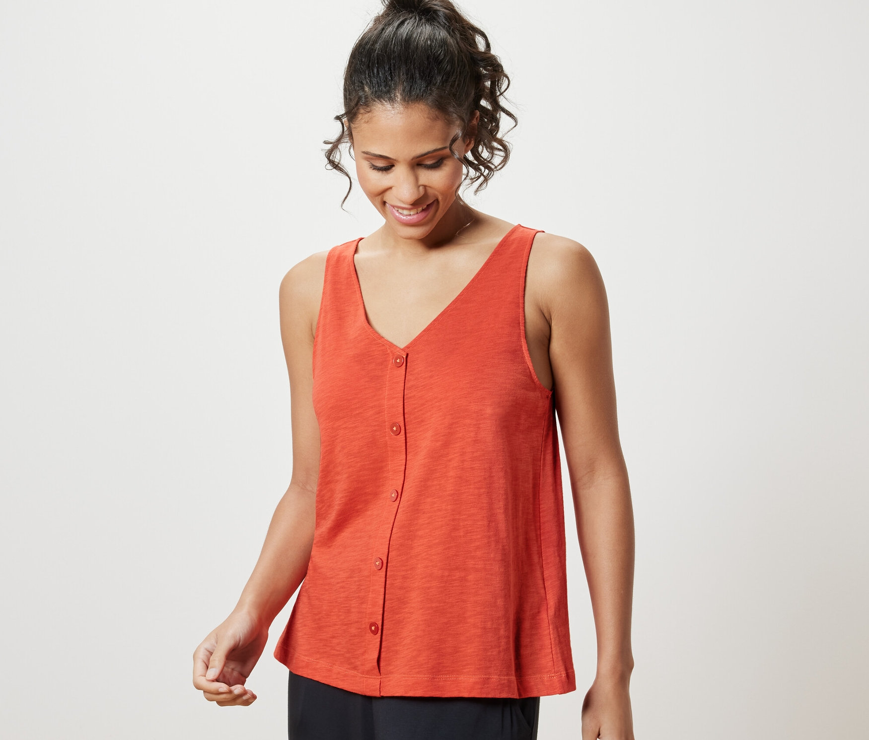 Kobieta ma na sobie pomarańczowy top z zawartością modalu.