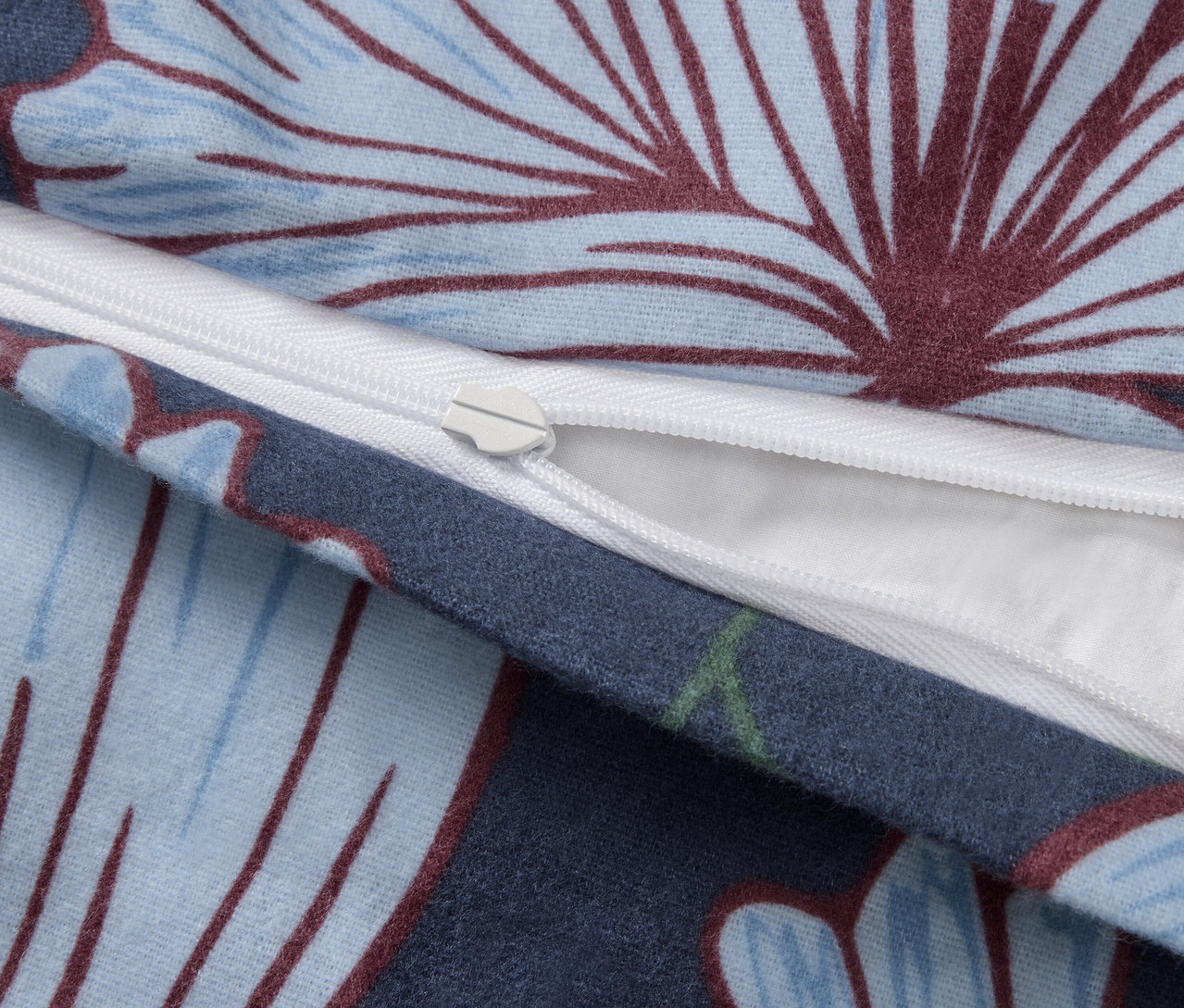 Zbliżenie na zamek błyskawiczny standardowej wielkości pościeli z flaneli w kwiatowy wzór.