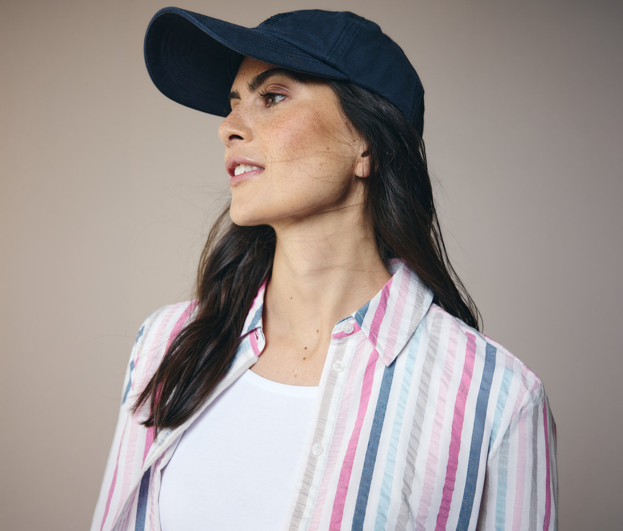 Kobieta w granatowej czapce i bluzce koszulowej CECIL w paski, patrzy w lewo.