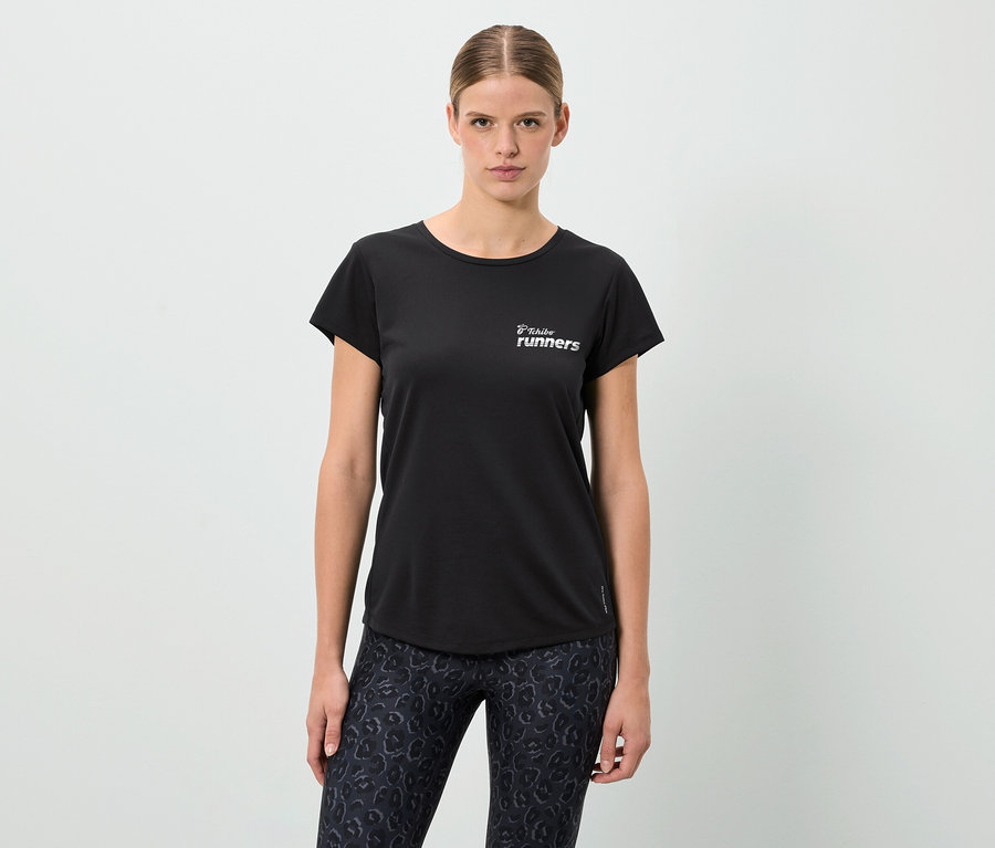 Kobieta w czarnym T-shircie z napisem "Tribal runners" i legginsach w panterkę.