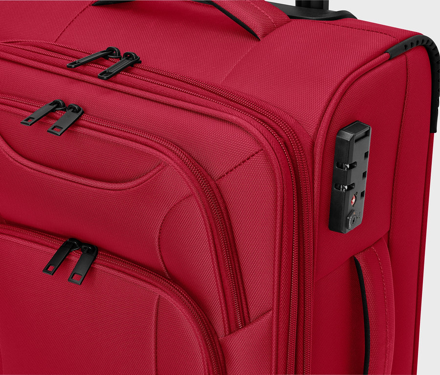 Szczegółowy widok czerwonej walizki z materiału z czarnymi zamkami błyskawicznymi i zamkiem szyfrowym.