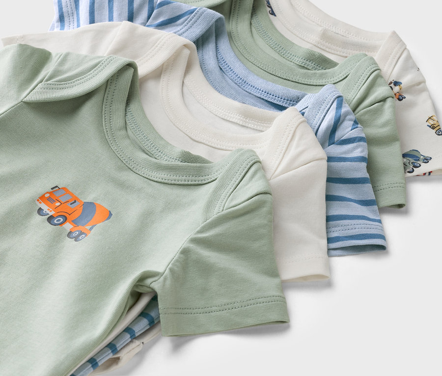 Zbliżenie na body niemowlęce z krótkim rękawem w różnych kolorach i wzorach, w tym zielone body z motywem betoniarki.