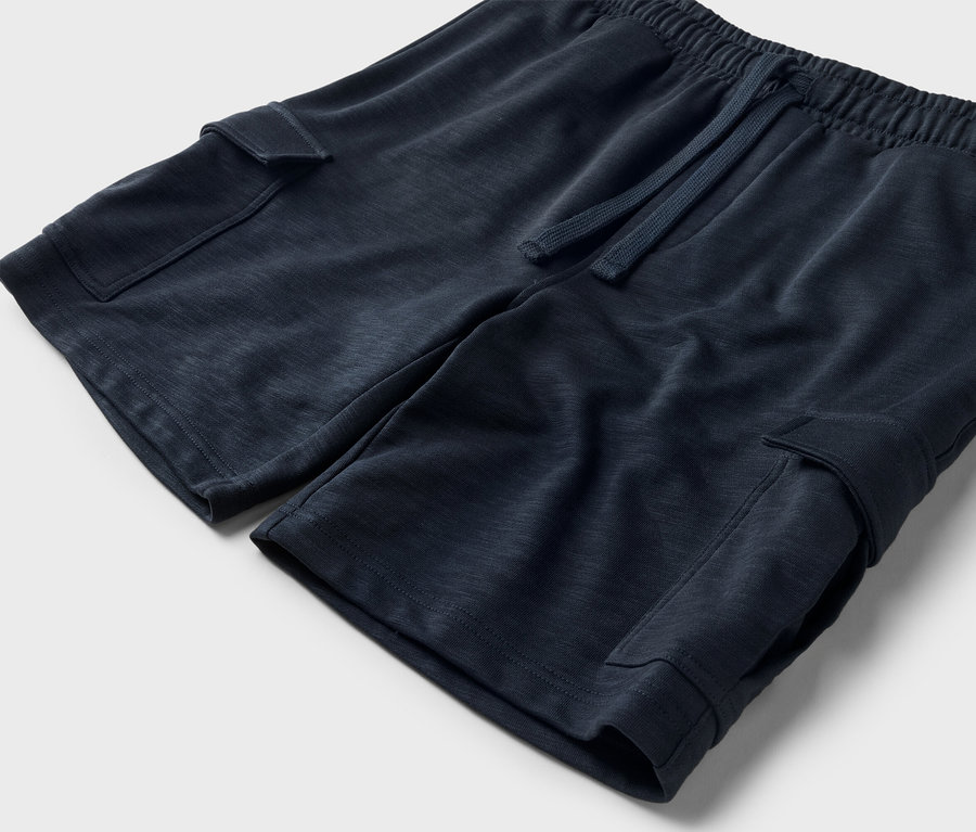 Zdjęcie z bliska granatowych szortów ze sznurkiem i kieszeniami cargo.