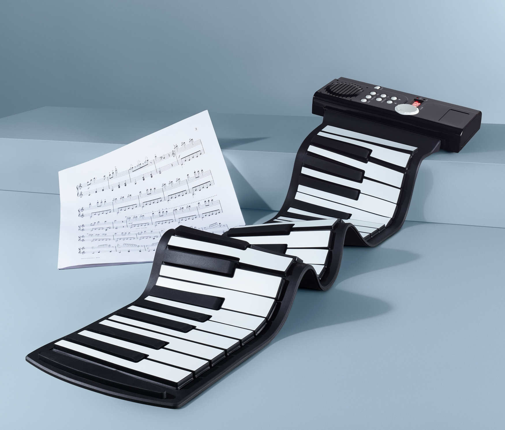 Elektryczne, zwijane pianino na niebieskim tle z nutami.