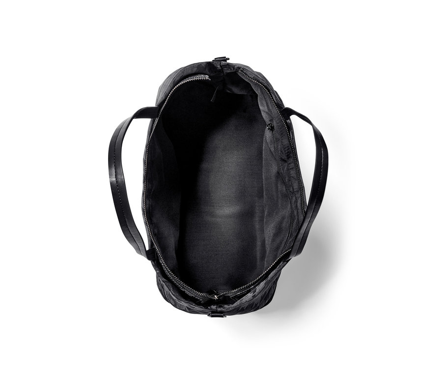 Czarna torba shopperka jest pusta i otwarta.