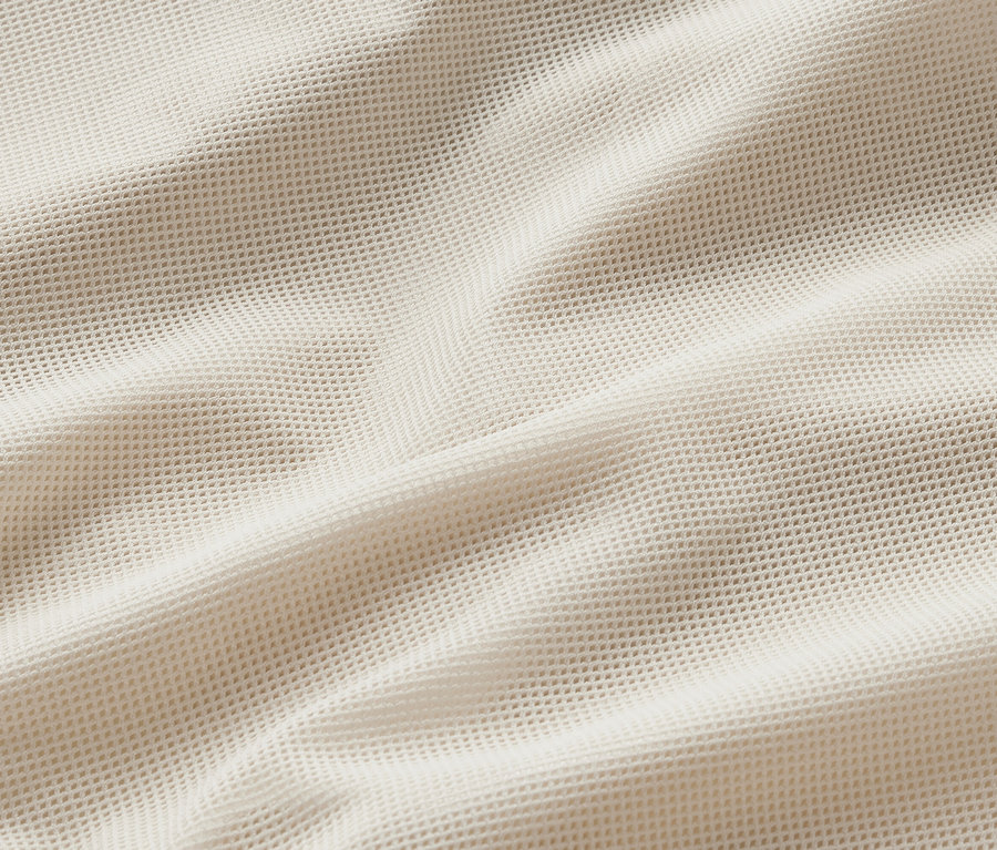 Zbliżenie na kremową, wiatroszczelną kurtkę do biegania.