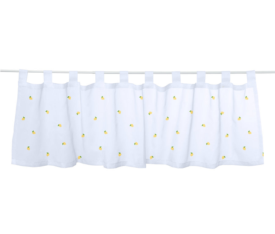Biała, haftowana zazdrostka z motywem cytryn, zawieszona na karniszu.