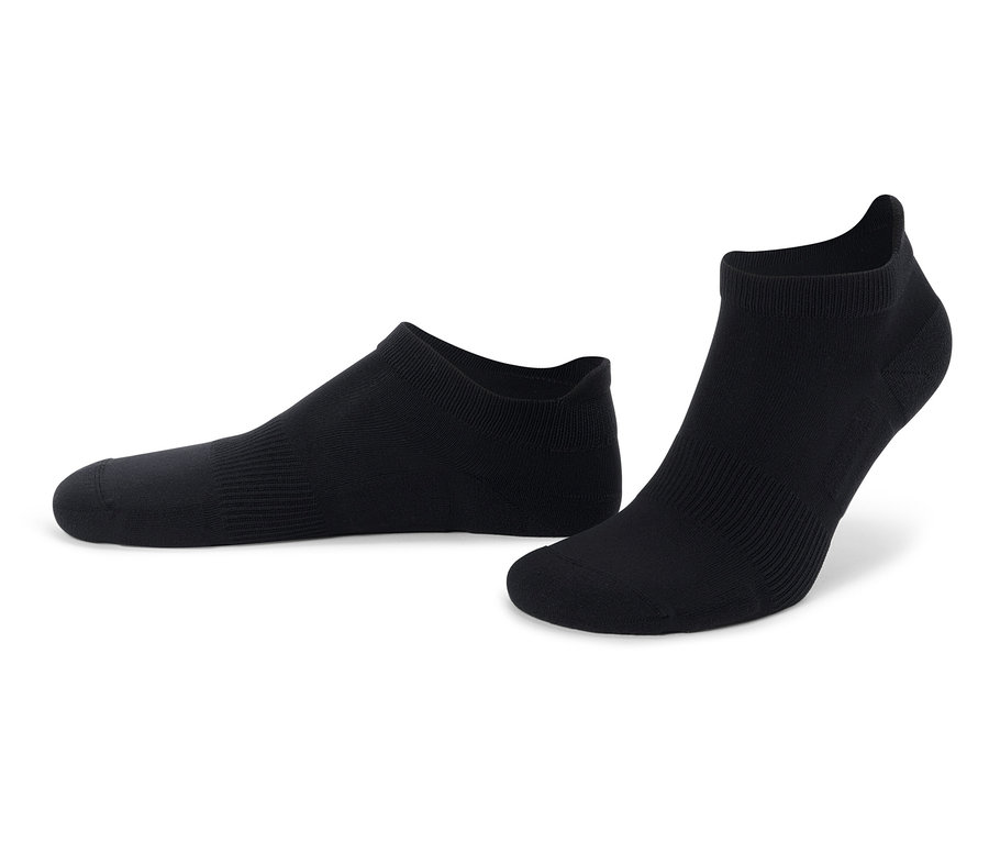 Dwie czarne skarpetki do kostki leżą na białym tle.