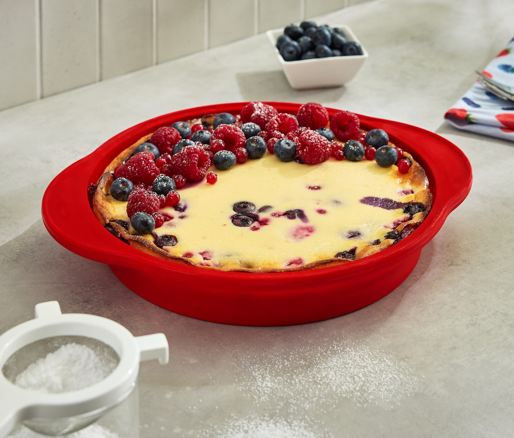 Ciasto w składanej formie do ciast, ozdobione borówkami i malinami.