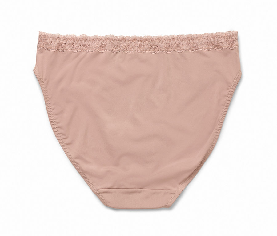 Zbliżenie pojedynczych, cielistych majtek z koronkowym wykończeniem w pasie.