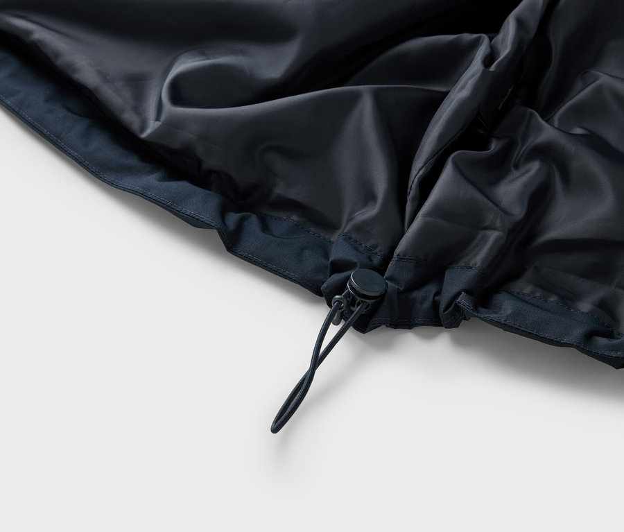 Szczegółowy widok wnętrza granatowej kurtki ze sznurkiem.